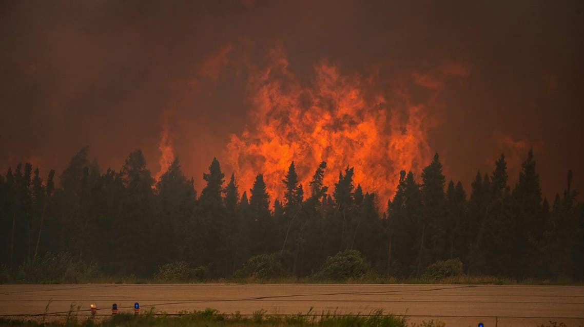 In this July 5, 2015 photo, flames rise from a wildfire near La Ronge, Saskatchewan. Canadian soldiers arrived Tuesday, July 7 to help battle raging wildfires where about 13,000 people have been evacuated in recent days. (Corey Hardcastle/Ministry of the Environment/Government of Saskatchewan via AP)