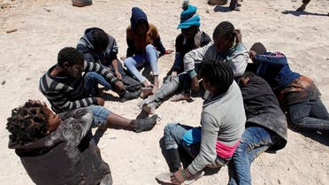 Migrants, who attempted to flee the Libyan coast to head to Europe, are seen sitting in a group after being detained at the coast guard center in the coastal city of Tripoli, Libya. (Reuters)