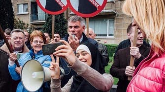 Muslim woman poses for selfies next to anti-Muslim protesters in Belgium
