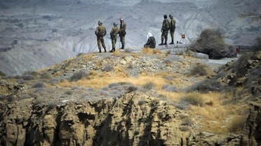 Members of Iran's Revolutionary guard personnel monitor an area as they stand on top of a hill while taking part in a war game in the Hormuz area of southern Iran in this file photo taken on April 24, 2010. REUTERS