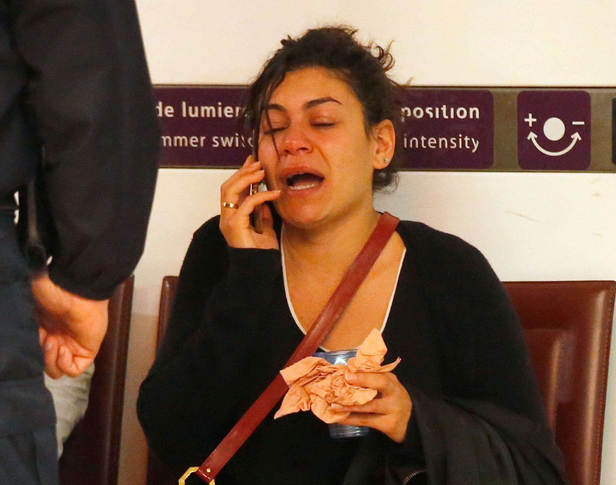 A relative of the victims of the EgyptAir flight 804 reacts as she makes a phone call at Charles de Gaulle Airport outside of Paris, Thursday, May 19, 2016.
