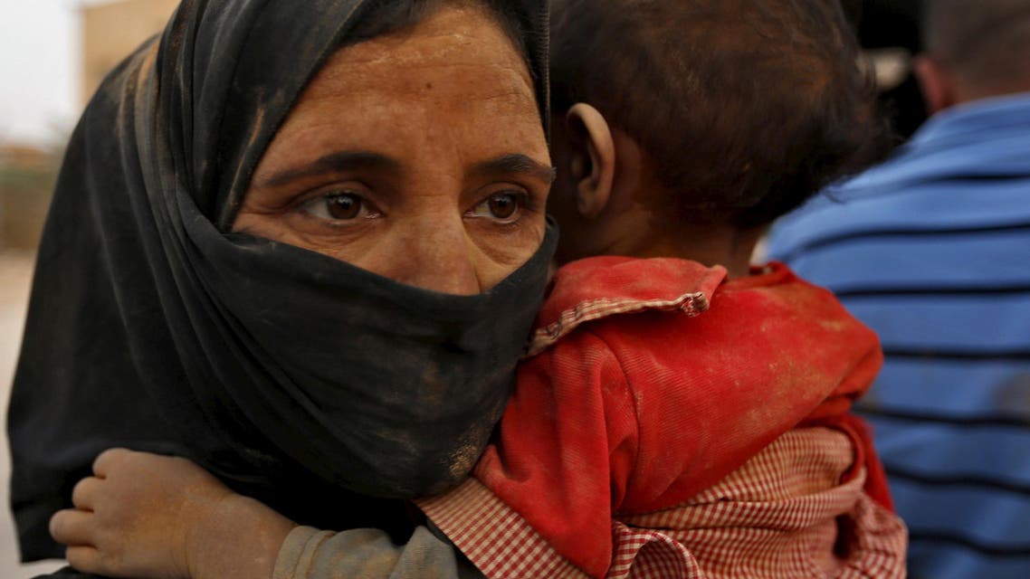 A Syrian refugees wwoman covered with dust carrys her daughter after her arrival at the Trabeel border, after she crossed into Jordanian territory with her family, near the northeastern Jordanian border with Syria, and Iraq, near the town of Ruwaished, 240 km (149 miles) east of Amman September 10, 2015. (Reuters)