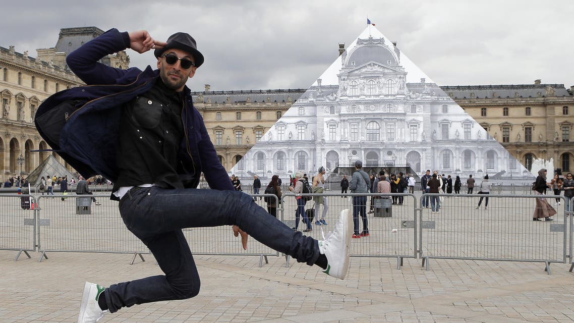 Street artist JR poses in front the Louvre Pyramid in Paris, Tuesday, May 24, 2016. ap