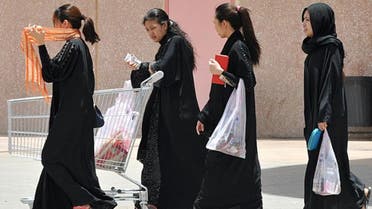 Filipina maids carry shopping bags as they walk out of a mall in Riyadh, on June 12, 2013. (AFP)