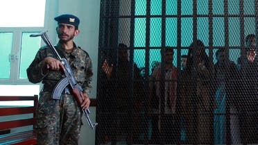 A Yemeni security officer guards prisoners at a court during a hearing at the appeals court in the Yemeni capital Sanaa on February 03, 2015. afp