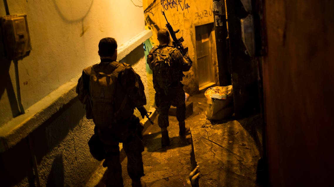 Police officers walk in an alley during a police operation at Rocinha slum in Rio de Janeiro, Brazil, Friday, May 20, 2016. (ap)