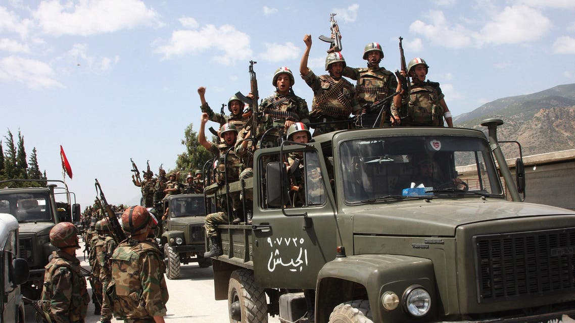 FILE - In this file photo taken on Friday, June 10, 2011, during a government organized tour for the media, shows Syrian army soldiers standing on their military trucks chanting slogans in support of Syrian President Bashar Assad, as they enter a village near the town of Jisr al-Shughour, north of Damascus, Syria. (AP Photo, File)
