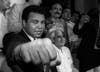 A smiling Muhammad Ali shows his fist to reporters during an impromptu press conference in Mexico City, July 1987.  (Reuters)