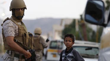 A boy stands next to soldiers from the Saudi-led coalition securing a street in Yemen's southern port city of Aden September 26, 2015. As Gulf-backed forces assemble in Marib province east of Sanaa ahead of a widely expected thrust towards the Houthi-held capital, the fate of Aden and its hinterland may offer a glimpse at whether some form of central government can be resurrected. Picture taken September 26, 2015. To match Insight YEMEN-SECURITY/ADEN REUTERS