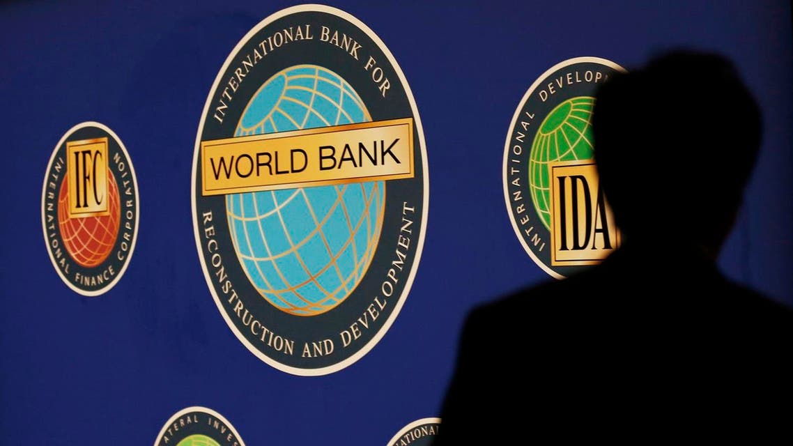 A man is silhouetted against the logo of the World Bank at the main venue for the International Monetary Fund (IMF) and World Bank annual meeting in Tokyo October 10, 2012. Japan is scheduled to host the IMF and World Bank annual meetings for the first time in nearly half a century. About 20,000 people are expected to attend the event, making it one of the world's largest international conferences. REUTERS
