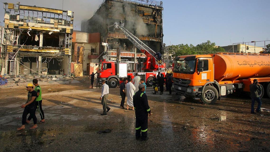 People gather as firefighters extinguish a fire following a car bomb attack at a commercial area in Karbala, 50 miles (80 kilometers) south of Baghdad, Iraq (Photo: AP)