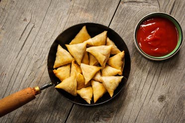 samoosa is a fried or baked dish with a savoury filling, such as spiced potatoes, onions, peas, lentils, macaroni, noodles, and/or minced meat (lamb, beef or chicken). (Shutterstock)