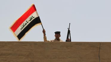 جندي عراقي يلوح بعلم بلاده في الصقلاوية - فرانس برس