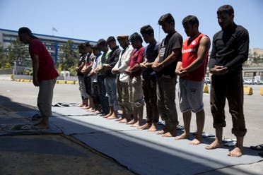 Afghan migrants stranded in Greece, pray on a dock at the port of Piraeus, near Athens on the first day of the holy fasting month of Ramadan. (AP)