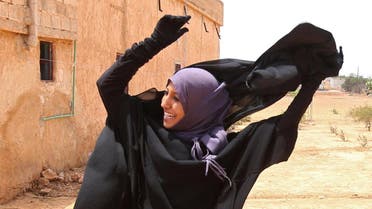 A woman removes a Niqab she was wearing in her village after Syria Democratic Forces (SDF) took control of it, on the outskirts of Manbij city, Aleppo province, Syria June 9, 2016.  (Reuters)
