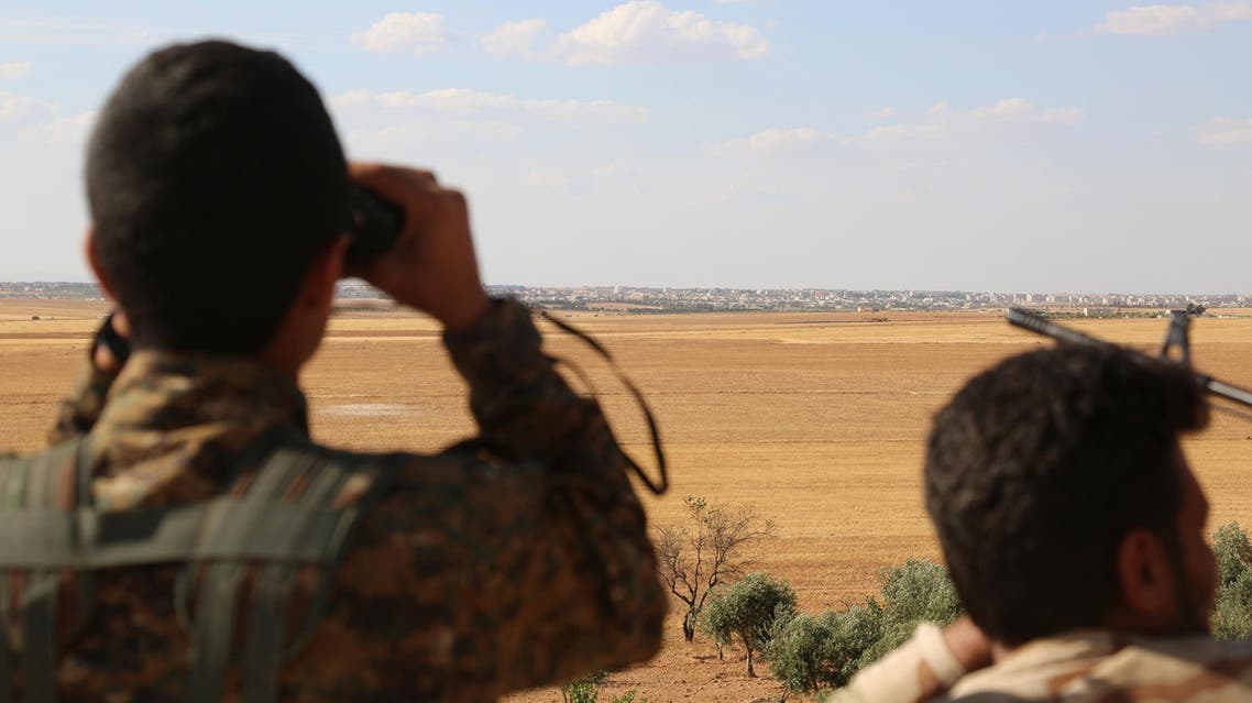Fighters from the Syrian Democratic Forces (SDF) use binoculars from a view point overlooking the northern Syrian town of Manbij held by the Islamic State (IS) group as they encircle the town cutting off the jihadists main supply route between Syria and Turkey on June 10, 2016. (AFP)