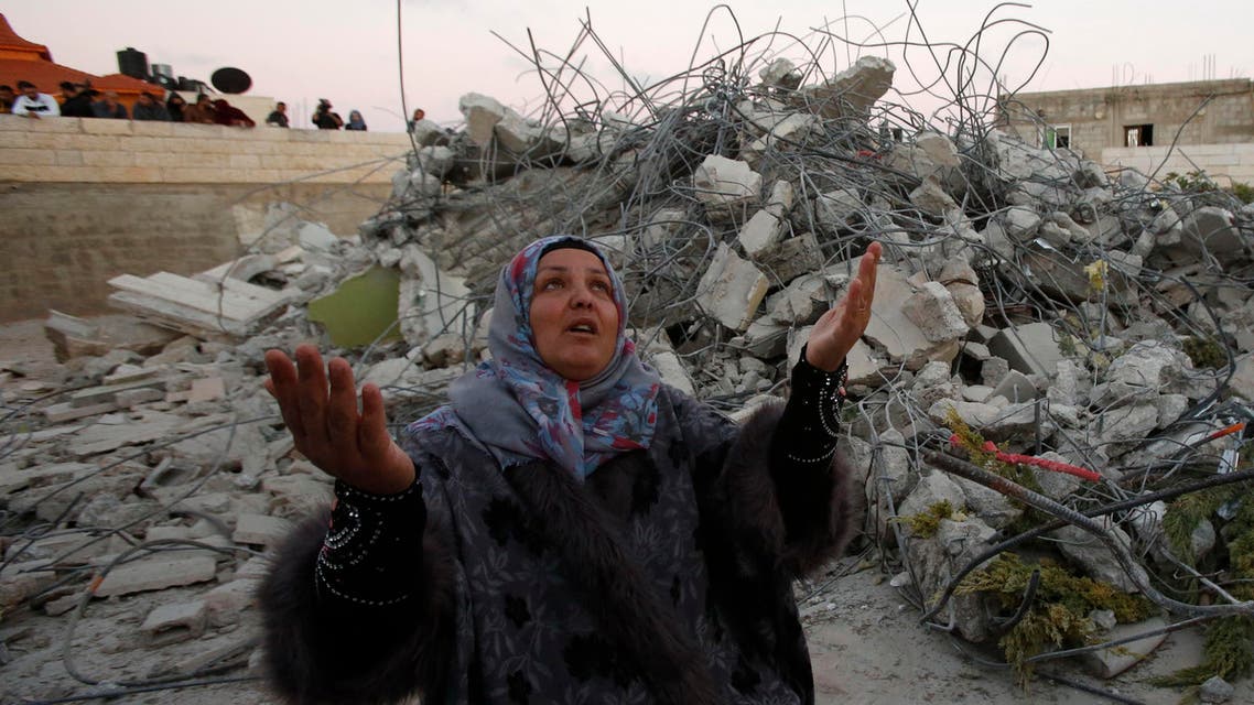 Maha the mother of 15-year old Palestinian teenager Murad Ideis, who was accused of stabbing to death a 38-year old Israeli nurse in an attack in the Israeli Otniel settlement in January 2016, reacts next to the rubble of her home after Israeli security force demolished the building in the West Bank village of Beit Amra, south of Hebron on June 11, 2016. (AFP)
