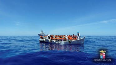 Migrants sit in their boat during a rescue operation by Italian navy ship Grecale (unseen) off the coast of Sicily, Italy, in this handout picture courtesy of the Italian Marina Militare released on May 6 2016. Marina Militare/Handout via REUTERS
