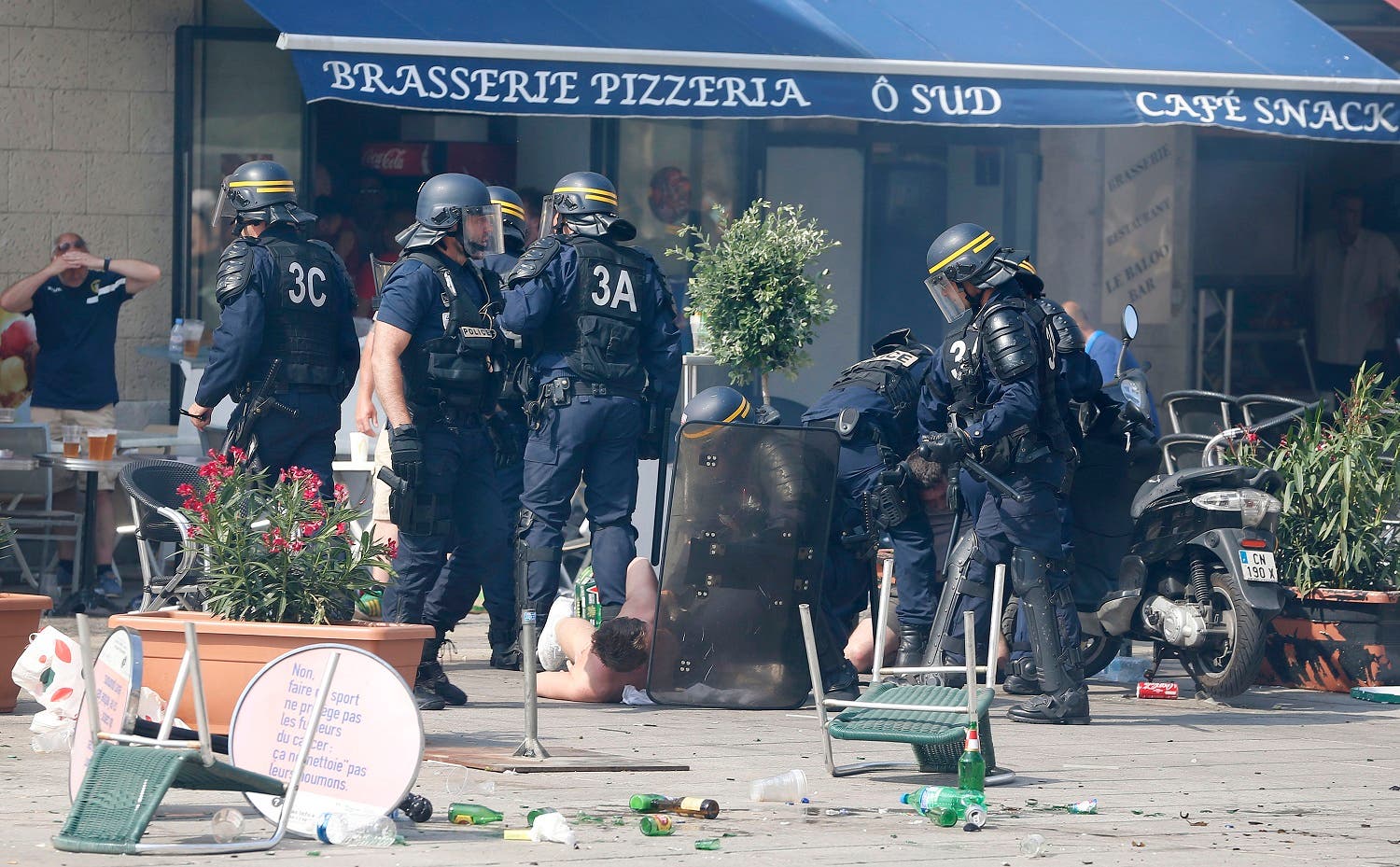 French police officers apprehend soccer supporters during clashes in downtown Marseille, France, Saturday, June 11, 2016. Riot police have thrown tear gas canisters at soccer fans Saturday in Marseille's Old Port in a third straight day of violence in the city. (AP