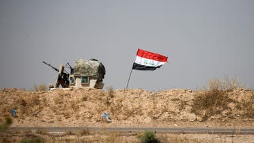 A military vehicle of the Iraqi security forces is seen next to an Iraqi flag in Falluja, Iraq, June 13, 2016. reuters