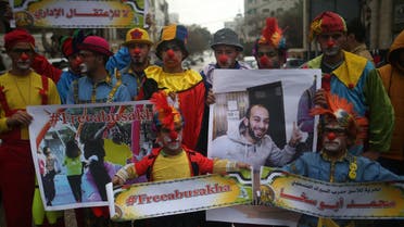 Palestinian clowns hold portraits of their colleague Mohammed Abu Sakha, who is imprisoned in an Israeli jail, as they demonstrate in solidarity with him on February 8, 2016 in Gaza City. MOHAMMED ABED / AFP
