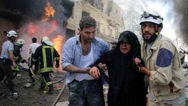Syrian civil defense workers, right, help an injured woman after warplanes attacked a street, in Aleppo, Syria. (AP)