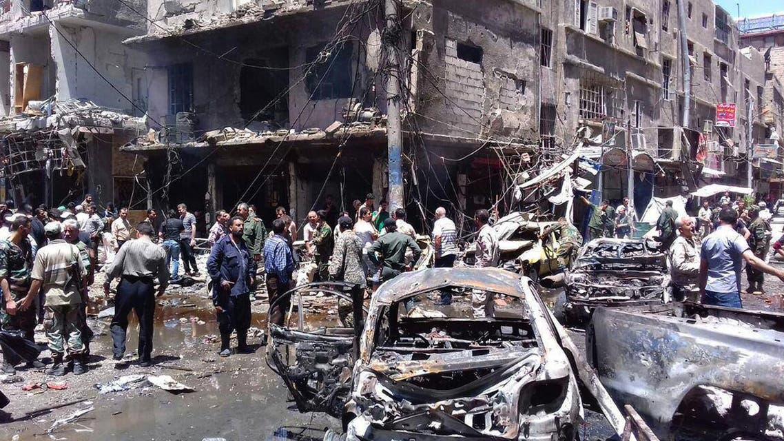 In this photo released by the Syrian official news agency SANA, Syrians gather around damaged buildings after a bombing attack at the Sayyida Zeinab suburb, Damascus, Syria, Saturday, June 11, 2016. (AP)