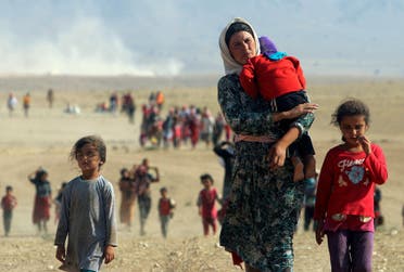 Displaced people from the minority Yazidi sect, fleeing violence from forces loyal to ISIS in Sinjar town, walk towards the Syrian border on the outskirts of Sinjar mountain near the Syrian border town of Elierbeh of Al-Hasakah Governorate in this August 11, 2014. (File photo: Reuters)