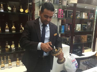Siraj Hassan Gawai, a branch manager and sales supervisor at Arabian Oud in Dubai demonstrates the burning of the oud. (Ismaeel Naar/Al Arabiya English)