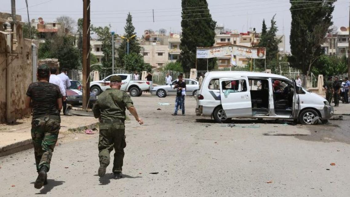 People and security forces belonging to the Sotoro, a Christian militia based in Syria's northeast, gather at the site of a suicide bomb attack carried out on June 19, 2016 in the divided Syrian city of Qamishli. (AFP)