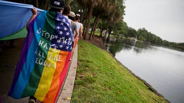 A marcher walks with a rainbow flag during a vigil in honor of the victims of the Pulse nightclub mass shooting. (AP)