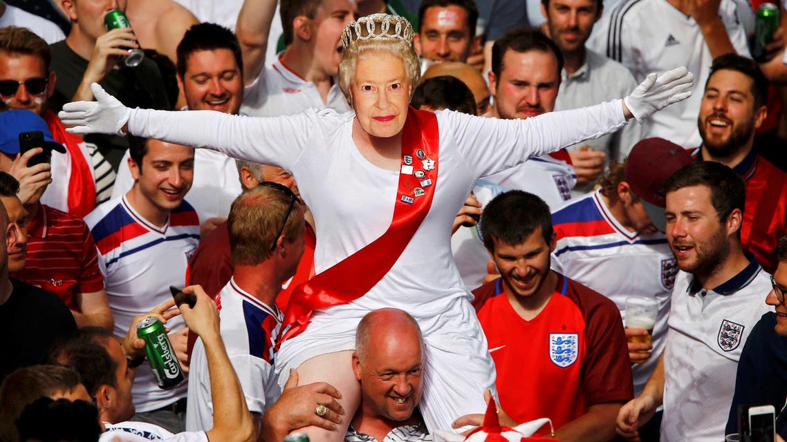 An England fan wears a mask of Queen Elizabeth II as he rides on the shoulders of his mates gathering in Saint Etienne ahead of their team's match against Slovakia. (Reuters)