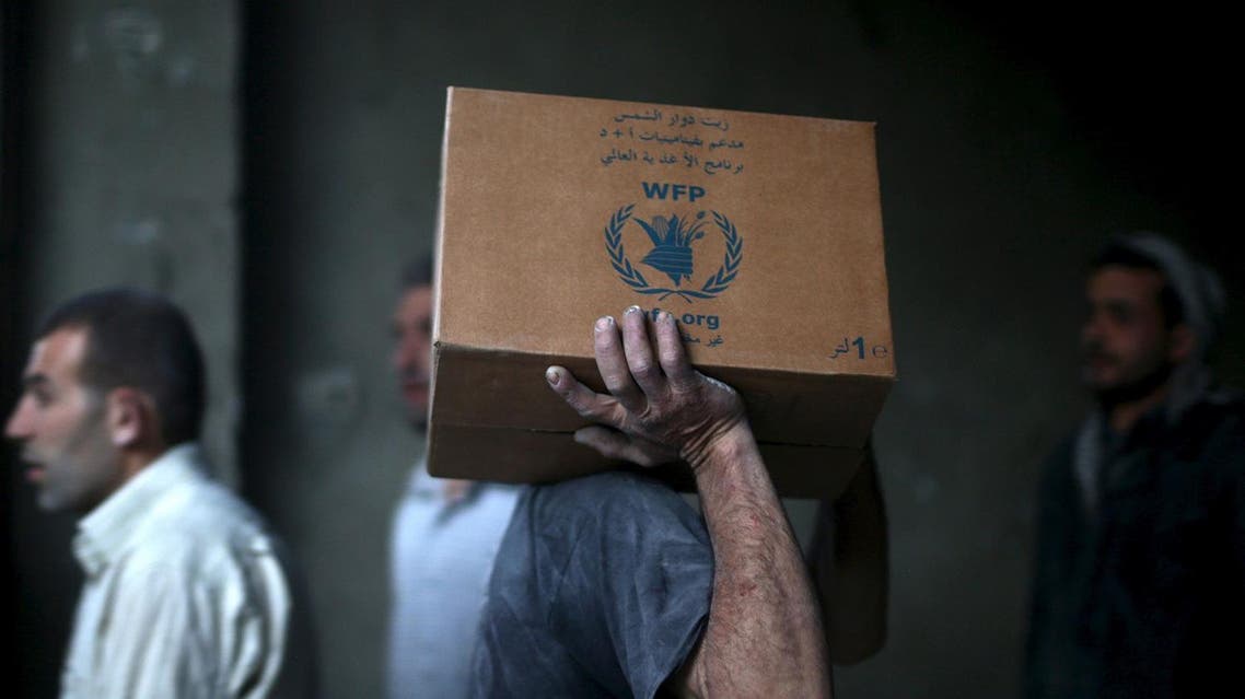 Men unloading aid boxes from a Red Crescent and United Nations(UN)aid convoy in the rebel held besieged town of Hamoria area, in the eastern suburbs of Damascus, Syria April 19, 2016. REUTERS