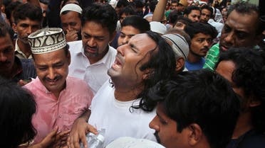 People comfort the brother, center, of famous Sufi singer Amjad Sabri, who was killed by unknown attackers, outside his residence in Karachi, Pakistan, Wednesday, June 22, 2016. (AP)