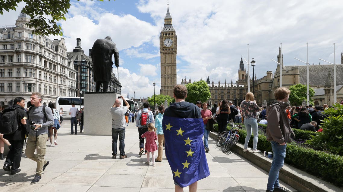 A demonstrator wrapped in the EU flag takes part in a protest opposing Britain's exit from the European Union in Parliament Square following yesterday's EU referendum result, London, Saturday, June 25, 2016. Britain voted to leave the European Union after a bitterly divisive referendum campaign. (AP Photo/Tim Ireland)
