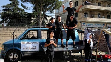In this photo taken on Tuesday June 21, 2016, Syrian refugee actors part of The Caravan, a street performance project touring Lebanon, perform at an open market in the eastern town of Saadnayel, in Bekaa valley, Lebanon. (AP