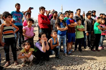 In this photo taken on Tuesday June 21, 2016, Syrian and Lebanese children watch a performance by The Caravan, a street performance project touring Lebanon, at an open market in the eastern town of Saadnayel, in Bekaa valley, Lebanon. The Caravan plans to tour Lebanon over the next six weeks, telling stories recorded and acted by Syrian refugees. And the range of reactions at the Saadnayel market is precisely what the directors of the project anticipated, even desired. Five years since the war in Syria, the influx has not stopped and Lebanese and Syrians alike are grappling to deal with the new reality in the absence of a political resolution. (AP)