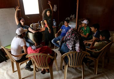In this picture taken on Tuesday May 3, 2016, Sabine Choucair, Lebanese artistic director of The Caravan, center, and her co-director Ailin Conant, left, train Syrian refugee actors during a rehearsal performance, at an informal refugee camp, in the eastern town of Bar Elias, in Bekaa valley, Lebanon. The Caravan, a street performance project that plans to tour Lebanon over the next six weeks, is a collection of stories told, recorded and acted by Syrian refugees. And the range of reactions at the Saadnayel market is precisely what the directors of the project anticipated, even desired. Five years since the war in Syria, the influx has not stopped and Lebanese and Syrians alike are grappling to deal with the new reality in the absence of a political resolution. (AP 