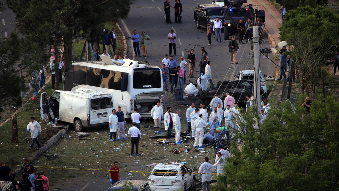 Security officers and medics work at the explosion site after a car bomb struck a bus in Diyarbakir, Turkey, Tuesday, May 10, 2016. AP