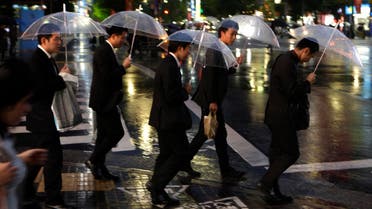 Japanese salarymen cross a street in Tokyo Monday, Nov. 15, 2010. (AP)