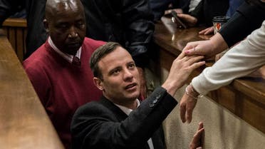 South African Paralympian athlete Oscar Pistorius holds the hand of a relative as he leaves the High Court in Pretoria, on July 6, 2016 after being sentenced to six years in jail for murdering his girlfriend Reeva Steenkamp (Photo: AFP)