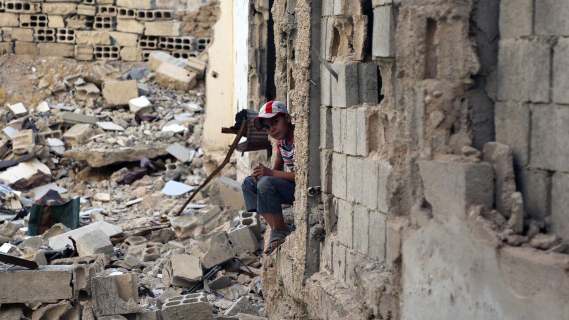 A Syrian boy sits amidst destruction during an activity organised by a charity group in Jobar, a rebel-held district on the eastern outskirts of the capital Damascus, ahead of Eid al-Fitr holyday in the war-torn country on July 5, 2016. AFP