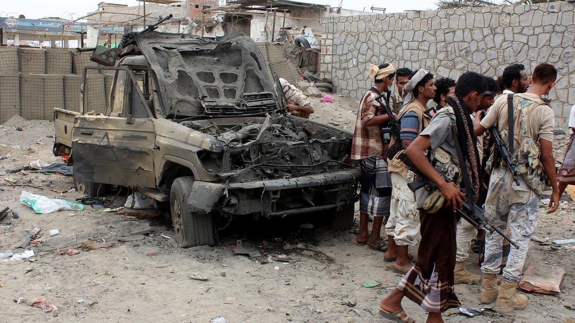 Armed Yemeni men stand next to destroyed vehicles after Yemeni government forces supported by a Saudi-led coalition recaptured an army headquarters near Aden airport from suspected militant after an hours-long firefight on July 6, 2016 in the southern city (Photo: AFP)