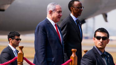 Israeli Prime Minister Benjamin Netanyahu stands (L) next to Rwanda's President Paul Kagame (R) at the airport in Kigali on July 6, 2016.