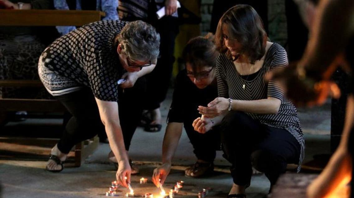 Iraqi Christians light candles during a mass in the memory of the victims of a suicide bombing, that ripped through Baghdad's busy shopping district of Karrada, on July 6, 2016. AFP