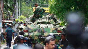 Bangladeshi soldiers and security personnel sit on top of armored vehicles as they cordon off an area near a restaurant popular with foreigners after heavily armed militants took dozens of hostages, in a diplomatic zone of the Bangladeshi capital Dhaka, Bangladesh, Saturday, July 2, 2016. Bangladesh forces stormed the Holey Artisan Bakery in Dhaka's Gulshan area Saturday morning, triggering explosions and finding bodies lying in pools of blood. (AP
