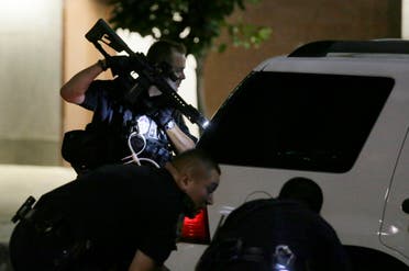 Dallas police check a car after detaining a driver in downtown Dallas, Thursday, July 7, 2016. Several police officers were shot by snipers, police said; some of the officers were killed. (AP)