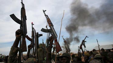 Rebel fighters hold up their rifles as they walk in front of a bushfire in a rebel-controlled territory in Upper Nile State, South Sudan February 13, 2014. (Reuters)
