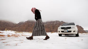 A man walks over snow after a snowstorm in the desert near Tabuk, northwest of Riyadh February 21, 2015. REUTERS