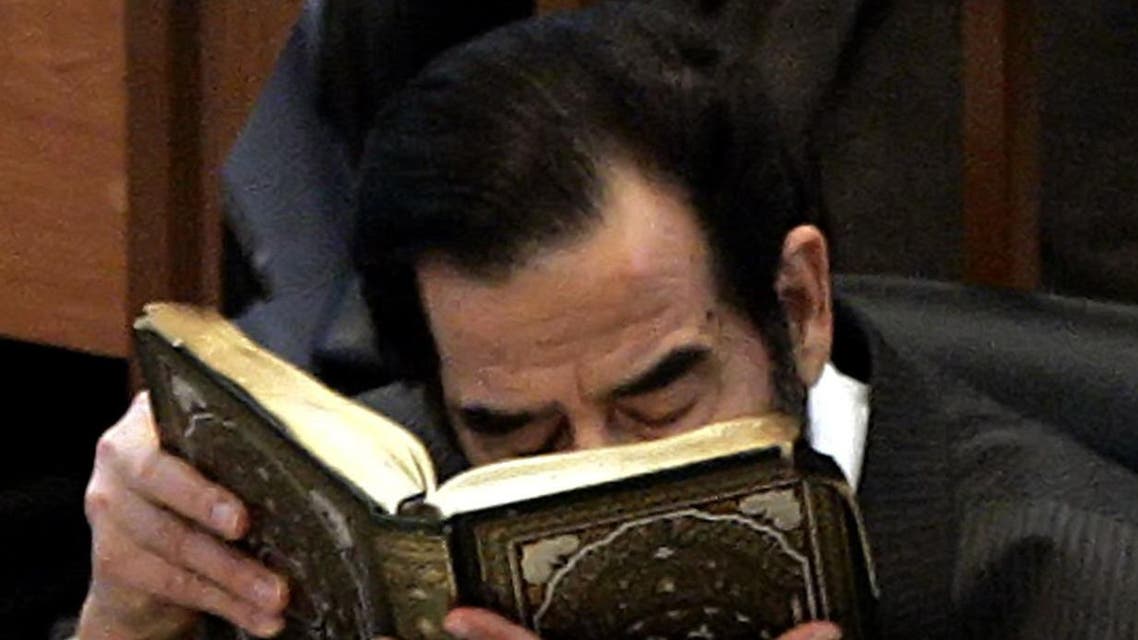 Former Iraqi President Saddam Hussein kisses the Holy Koran moments after addressing the court during his trial in Baghdad, 06 December, 2005. (AFP)